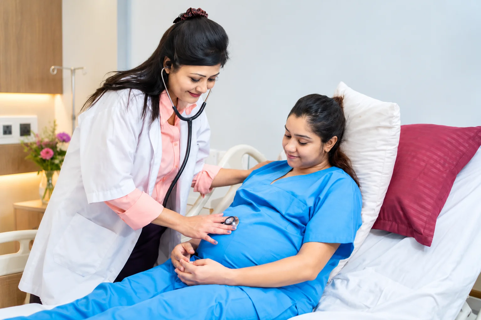 A doctor examining a pregnant patient during a clinic follow-up visit
